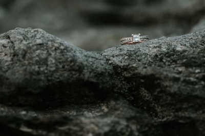 金黄色透明宝石镶嵌在岩石上的戒指